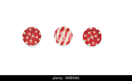 Three Various red sewing buttons isolated on background. Stock Photo