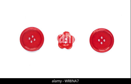 Three Various red sewing buttons isolated on background. Stock Photo