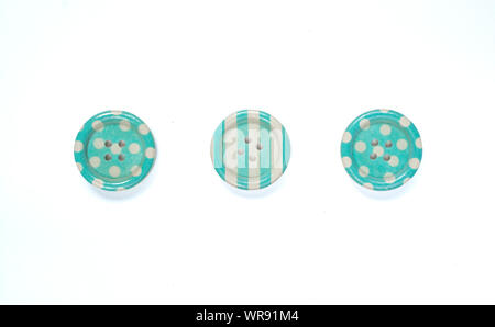 Three Various blue sewing buttons isolated on background. Stock Photo
