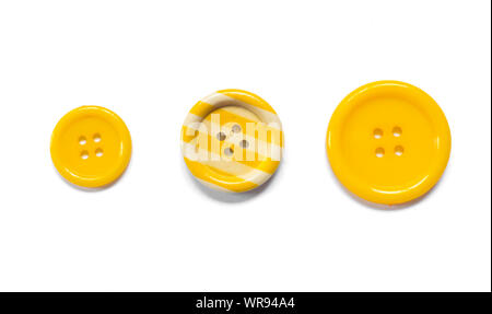 Three Various yellow sewing buttons isolated on background. Stock Photo