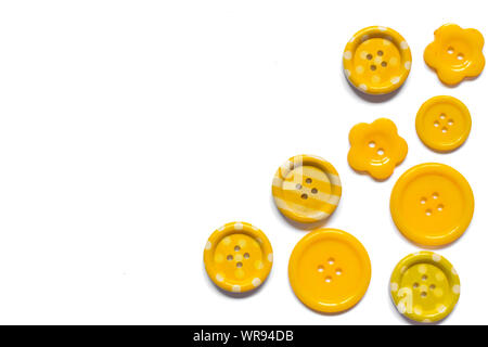 Various yellow sewing buttons isolated on white background. Stock Photo