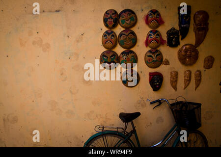 Colourful hand painted Chinese opera masks hang up neatly on a