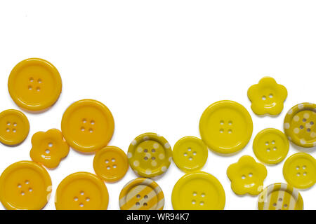 Various yellow sewing buttons isolated on white background. Stock Photo