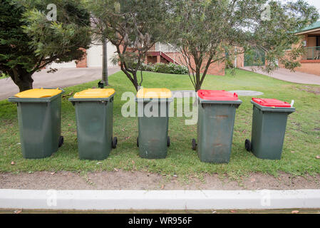 Red top rubbish and yellow top recycling bins await collection outside homes in Kioloa on the South Coast of New South Wales, Australia Stock Photo