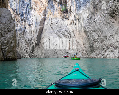 Group of tourists in a sit on top kayaks explore Congost de Mont-rebei (Mont-rebei gorge) at Noguera Ribagorcana river, Spain. First-person view. Stock Photo