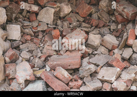 Pile of broken bricks. Grunge background. Red brick. Antique texture. Danger of destruction building. Stock Photo