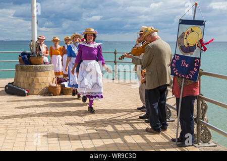 Female clog dancers, members of the Beetlecrushers perform on Swanage Pier at Swanage Folk Festival, Swanage, Dorset UK on warm sunny day in September Stock Photo