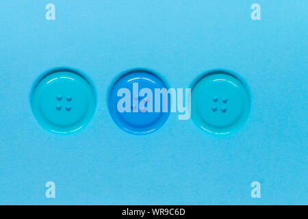 Three Various blue sewing buttons on blue background. Stock Photo