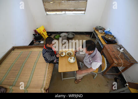 (190910) -- NANNING, Sept. 10, 2019 (Xinhua) -- Teacher Lan Qifei and student Lan Mengyuan have lunch at a teaching point of Yide primary school in Jingsheng Town, Du'an Yao Autonomous County, south China's Guangxi Zhuang Autonomous Region, April 15, 2015. Then Lan Qifei was the only teacher and Lan Mengyuan was the only student at the teaching point. Since 2012, reporter has visited 250 teachers in remote mountain areas in Guangxi and recorded their lives. Teachers there always fill multiple roles, such as concierge and cook.  There are about 16.74 million teachers in China, a 79 percent surg Stock Photo