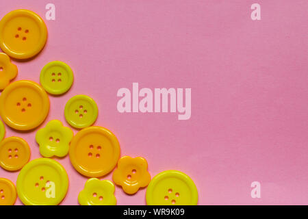 various yellow buttons on light pink background with place for text Stock Photo