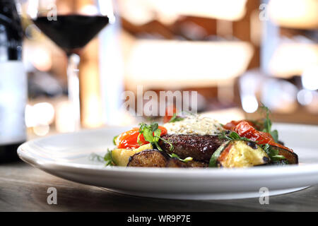 Entrecote steak with herb butter and grilled vegetables served with a glass of red wine. Stock Photo