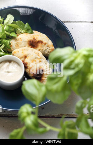 Appetizer. Crunchy stuffed calzone with garlic yoghurt sauce. Stock Photo