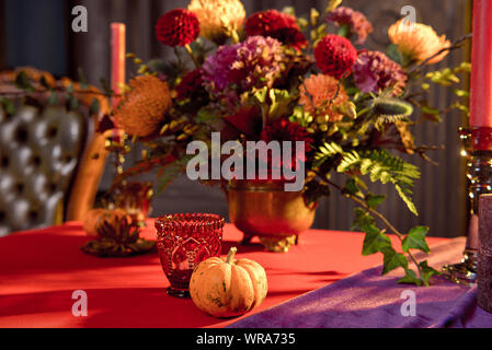 Halloween table festively decorated composition of flowers candles candles pumpkin glasses with wine Stock Photo
