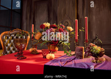 Halloween table festively decorated composition of flowers candles candles pumpkin glasses with wine Stock Photo