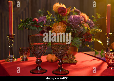 Halloween table festively decorated composition of flowers candles candles pumpkin glasses with wine Stock Photo