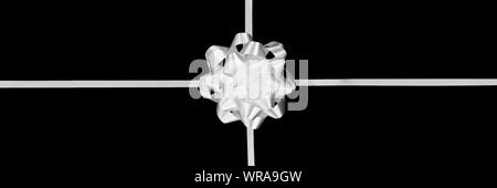 White gift bow and ribbon isolated on panoramic black background Stock Photo