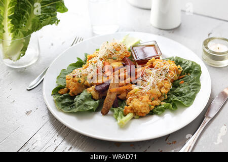 Baked vegetables, sweet potato, potato, celery, carrot, beet served with vegetable stew on iceberg lettuce.