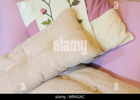 Beige and purple cushions on a sofa in a living room Stock Photo