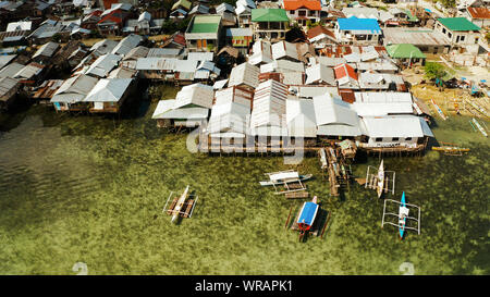 Old wooden house standing on the sea in the fishing village, aerial view. Dapa, Siargao, Philippines. Stock Photo