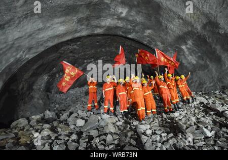 Chinese construction workers celebrate after the left route of the Changchengwu Tunnel broke through in Huzhou City, east China's Zhejiang Province, J Stock Photo