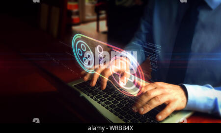 Man typing on laptop with game pad with key symbol hologram screen over keyboard. Gaming, 5G, play and online game concept. Stock Photo