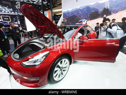 **FILE**Visitors try out and view a Tesla Model 3 electric car on display during the 15th Beijing International Automotive Exhibition (Auto China 2018 Stock Photo