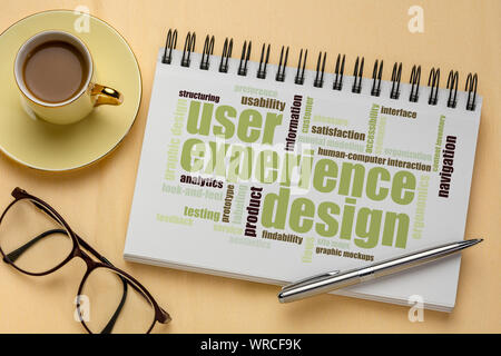user experience design concept - word cloud in a spiral sketchbook with a cup of coffee Stock Photo