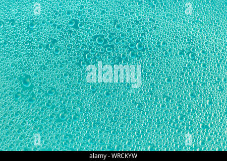 Water drops on turquoise surface. Blue and green abstract background of soap bubbles. Aquamarine texture of shiny glass. Drops pattern. Transparent co Stock Photo