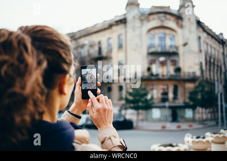 Young woman photographed on a mobile phone old building while traveling Stock Photo