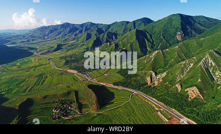 (190910) -- BEIJING, Sept. 10, 2019 (Xinhua) -- Aerial photo taken on July 17, 2018 shows the Liupanshan Mountain and farmlands on its foot in Longde County of Guyuan City, northwest China's Ningxia Hui Autonomous Region. Located in the northwestern China, Ningxia is rich in natural beauties ranging from waterside landscape to scenery in cold regions. As an important protection barrier of ecological system in northwestern China, Ningxia plays a significant role in safeguarding the whole country's ecological environment.   Surrounded by deserts on three sides, Ningxia is faced with arduous task Stock Photo