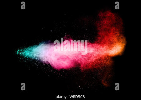 Multi colored particles explosion on black background.Colorful dust splash. Stock Photo