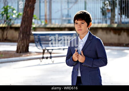 Young boy wearing a jacket waiting in a square Stock Photo