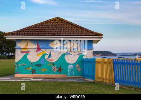 Colourful hut with painted artwork on side and painted fences at Hamworthy Park, Poole, Dorset UK in August Stock Photo
