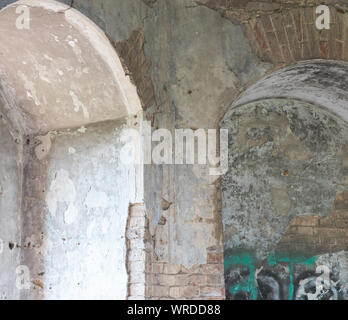 interior view of an abandoned old building with an arch in the wall Stock Photo