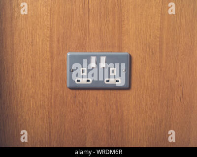 A UK British electrical wall socket on wooden wall Stock Photo