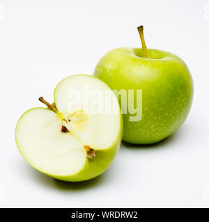 Green apples, whole and sliced in half on a white background Stock Photo