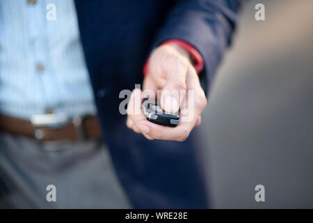 Businessman holding car keys while running late for work Stock Photo