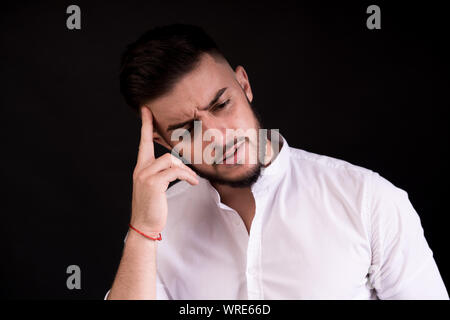 Portrait of bearded thoughtful handsome man in casual style thinking. studio shot on black background. Stock Photo