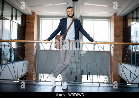 Office worker standing and waiting for his colleague near stairs Stock Photo