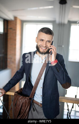 Smiling businessman speaking with colleague by the phone Stock Photo