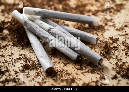 Hand rolling tobacco on a wood table Stock Photo
