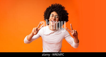 Cool african american guy smiling and demonstrating v-signs Stock Photo