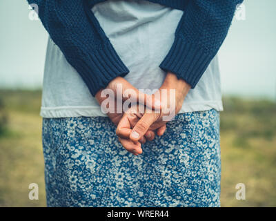 A young woman is resting her hands behind her back Stock Photo