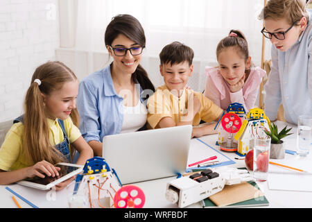 Kids learning about computers and robots with their teacher Stock Photo