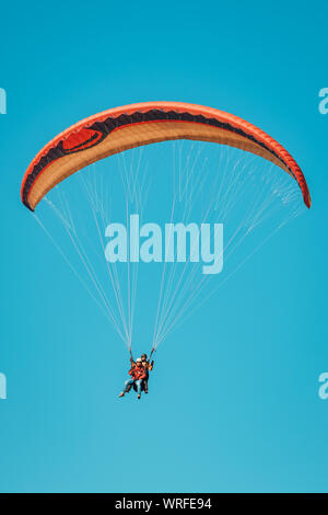 Colorful paraglider on blue bright sky close-up Stock Photo