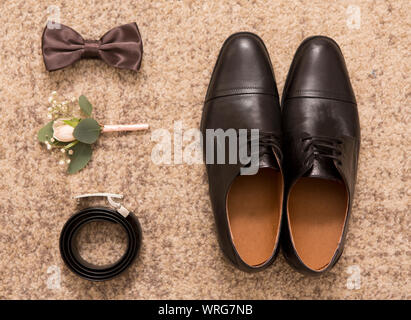 Groom accessories and black shoes on brown background Stock Photo