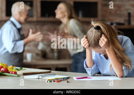 Upset girl crying while her mom and granny fighting Stock Photo