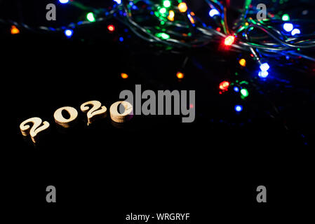 New year 2020 with numbers and bright lights on dark background and free space for text. Stock Photo