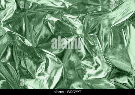 Textured silver foil background with shiny crumpled surface in trendy neo mint color of the year 2020. Stock Photo