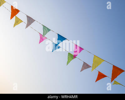 multicolored pennants on a blue sky background Stock Photo
